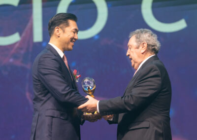 At the Global Peace Convention, a man in a suit is shaking hands with another distinguished individual at the Awards Gala.