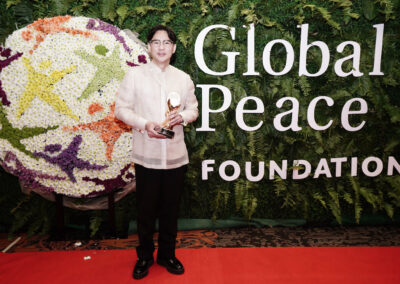 A man standing in front of a red carpet at the Global Peace Convention Awards Gala.