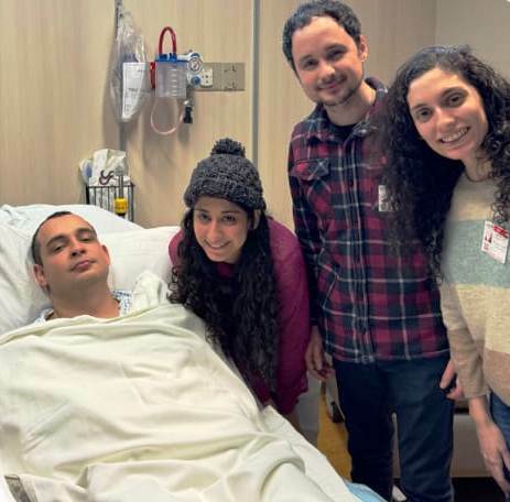 A group of people from GPF Brazil posing for a photo in a hospital bed.