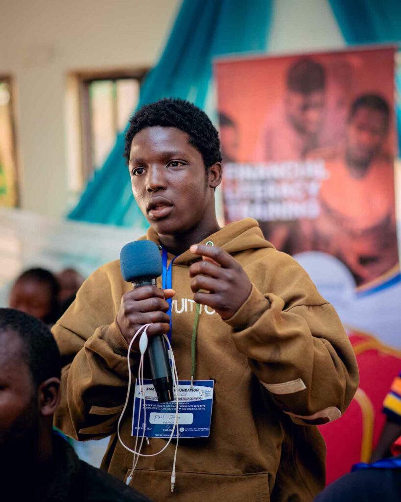 A person speaking into a microphone at a drug abuse prevention event hosted by GPF Nigeria.