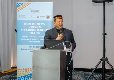 A speaker stands at a podium addressing an audience during the Community-Driven Peacebuilding Track at GPLC Africa 2024 in Nairobi, Kenya, on June 26.