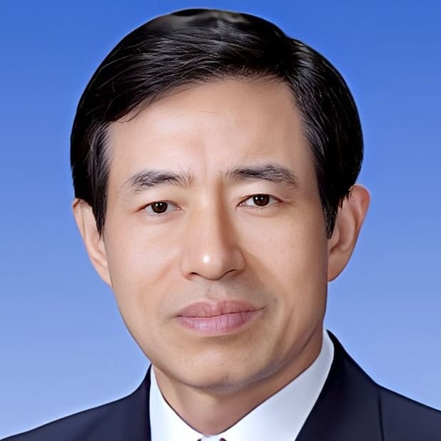 Kyung-young-Chung Portrait of a man with short black hair, wearing a dark suit and white shirt, posed against a gradient blue background.
