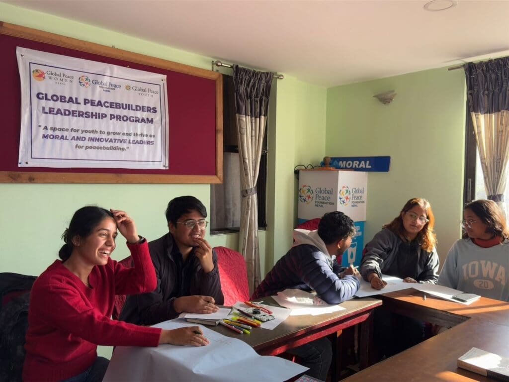 Five people sit together in a room under a banner that reads 
