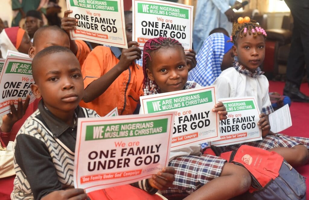 Children in a group from Niger State hold signs reading,