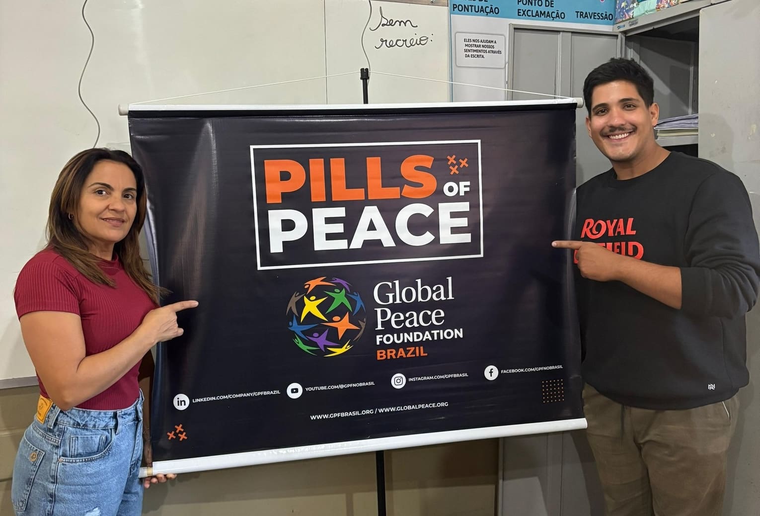 Two people stand beside a banner that reads 