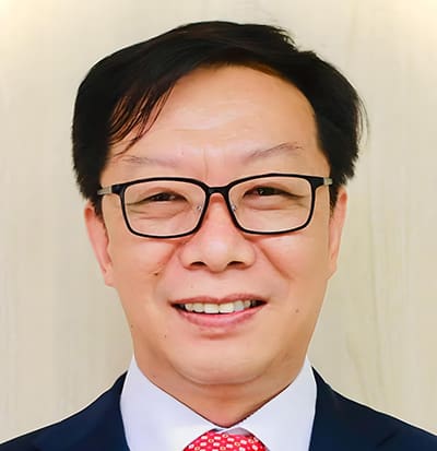 Zhongyi Zhang Dr. Zhongyi Zhang, a man with short black hair and glasses, wearing a dark suit, white shirt, and red patterned tie, smiles at the camera against a light-colored background.