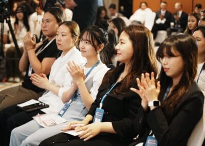 A group of people seated in an audience, attentively listening and applauding during the Mongolia Forum on Northeast Asian Peaceful Development and Korean Unification.