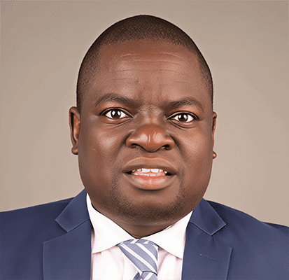 S2 Lessons Learned Latin America & Africa 6. Hon. Ikana Fredrick Lusuli Jamil Mahuad, dressed in a blue suit, white shirt, and striped tie, poses against a plain background. He has short hair and a neutral facial expression.