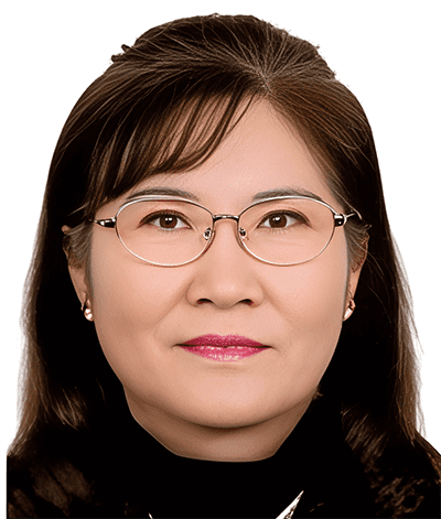S3 Role of Korean Diaspora 3. Mi-soon Kim Dr. Pil-hyun Koo, a woman with straight dark hair, wearing eyeglasses, gold earrings, and a dark top, poses for a formal portrait against a plain white background.