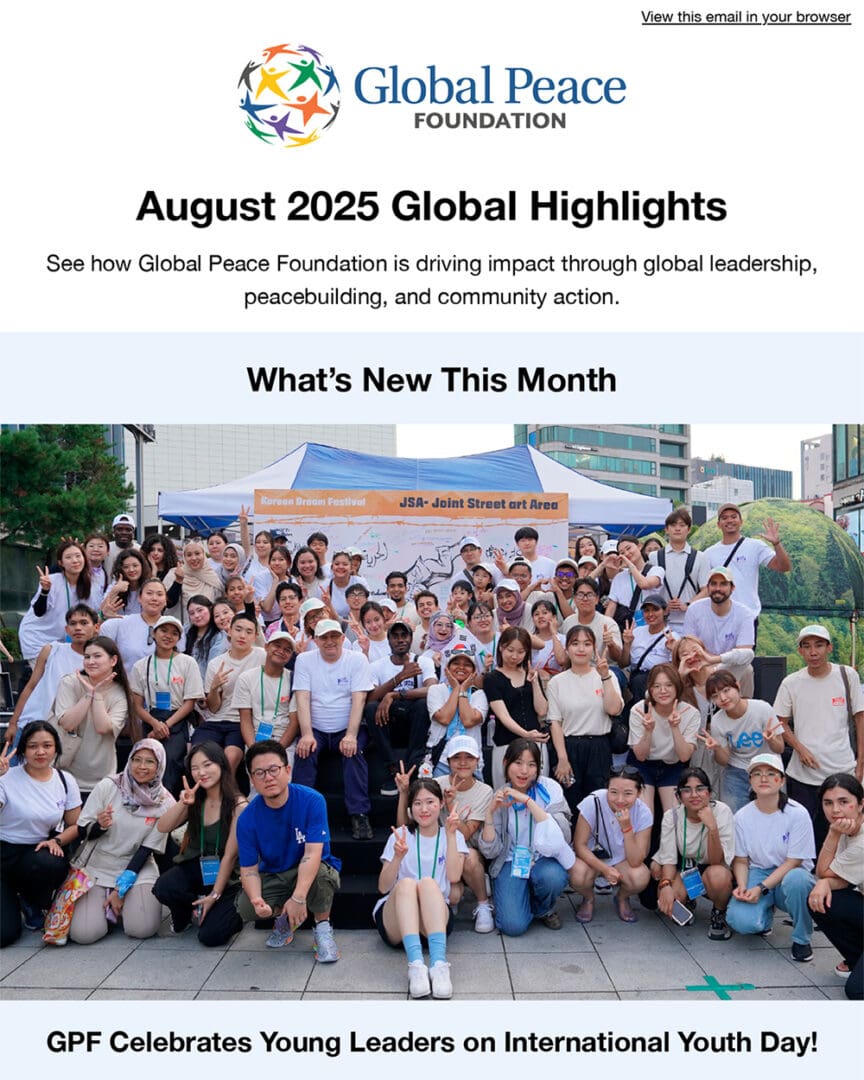 A large group of young people pose together outside under a canopy tent, celebrating International Youth Day with the Global Peace Foundation.