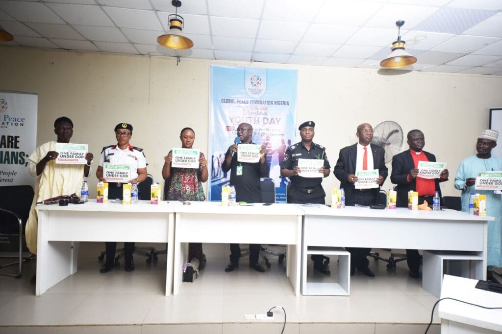 A group of people stands behind a table holding signs, with a 