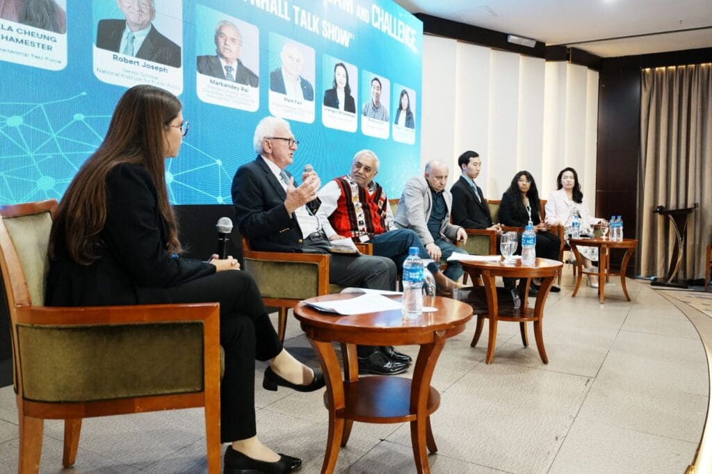 Seven panelists sit on stage at the Young Leaders Mongolia conference, discussing leadership development with microphones in hand and a large event banner featuring headshots and information behind them.