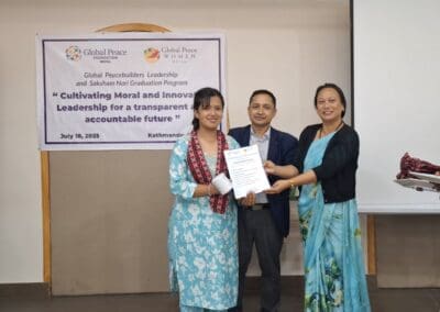 Three people stand indoors, smiling as one woman receives a certificate. A banner behind them reads: "Cultivating Moral and Innovative Leadership for a transparent and accountable future." This event celebrates the Saksham Nari Fellows of GPF Nepal.