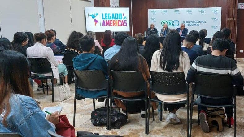 A group of people sit facing a panel of speakers in a conference room, with banners for “Legacy of the Americas” and the Global Peace Foundation visible at the front, highlighting collaboration across Latin America.