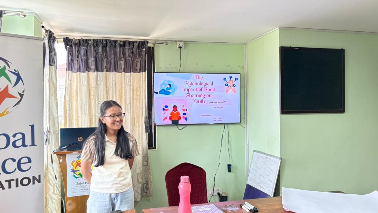A woman stands in front of a presentation slide titled