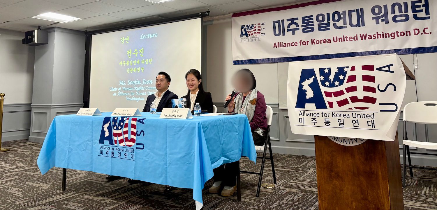 Three speakers sit at a table with microphones at a talk concert hosted by AKU Washington; a banner and presentation screen are visible.