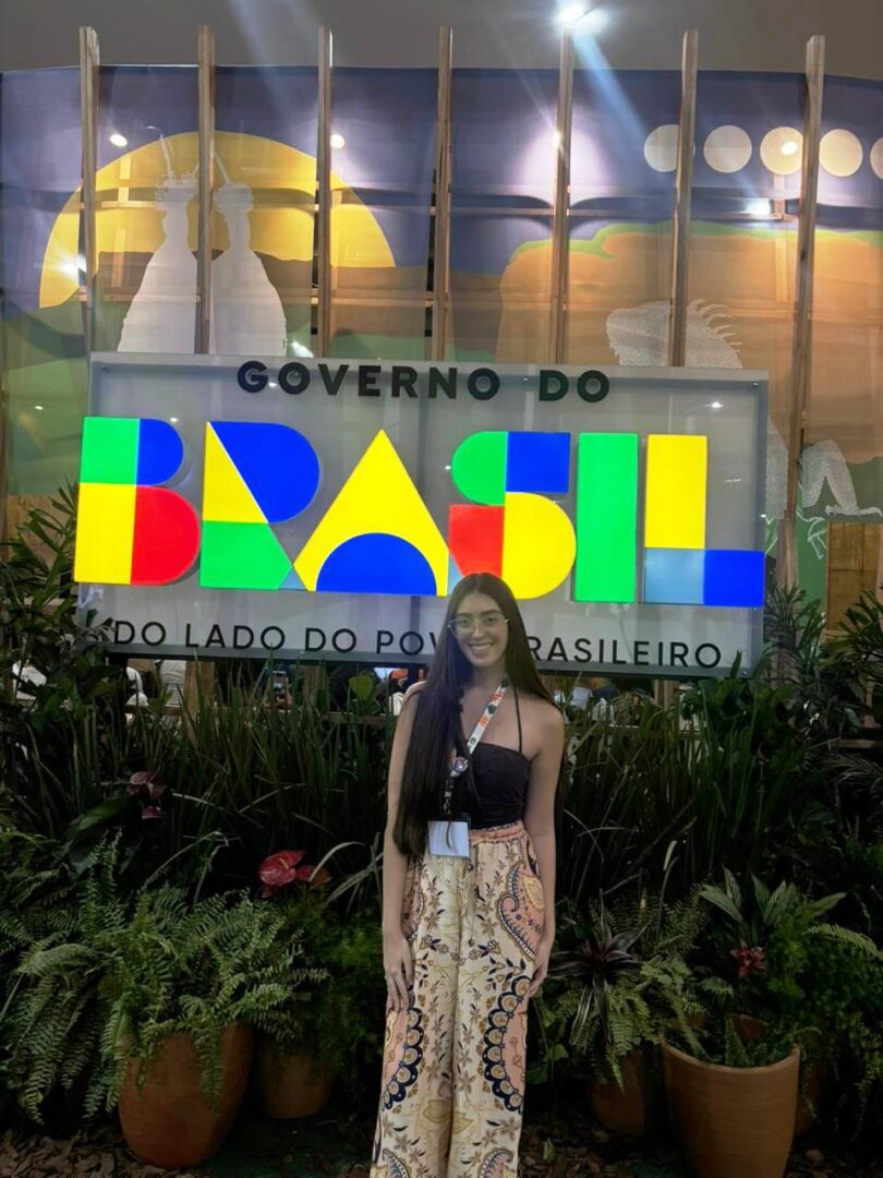 A woman stands and smiles in front of a colorful