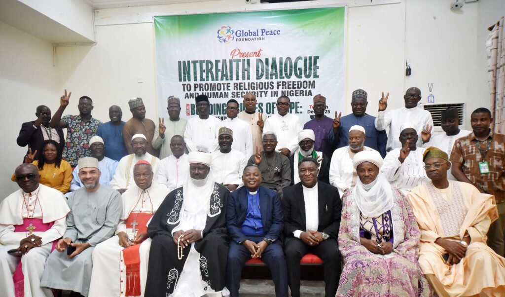 A group of men and women, including interfaith leaders, pose together at an