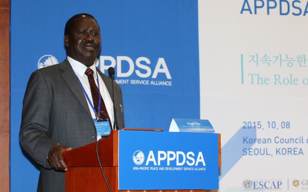 A man in a suit speaks at a podium during the APPDSA conference in Seoul, Korea, on October 8, 2015. A blue and white event banner is visible in the background.