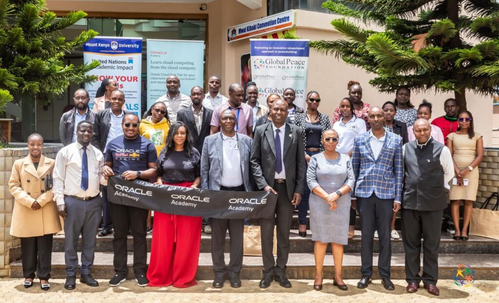A group of computer science educators pose for a photo outside a building, holding an