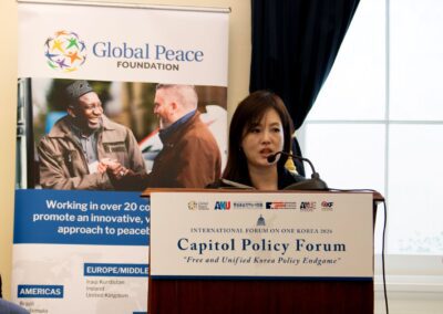 A woman speaks at a podium during the Capitol Policy Forum, part of the International Forum on One Korea, with a Global Peace Foundation banner visible in the background.
