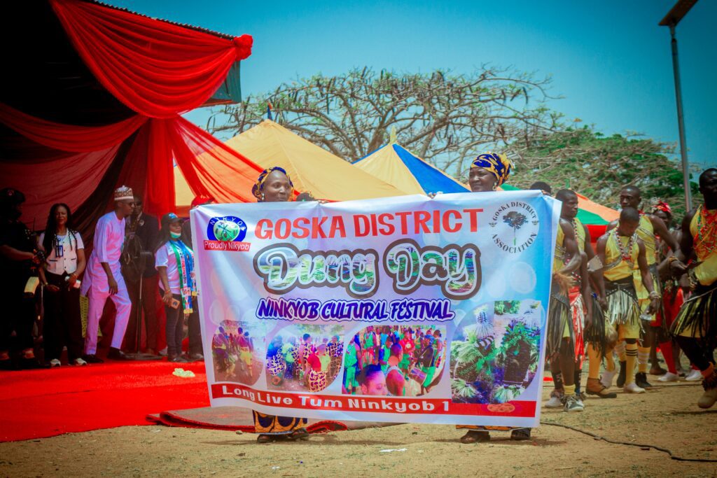 A group of people hold a colorful banner reading