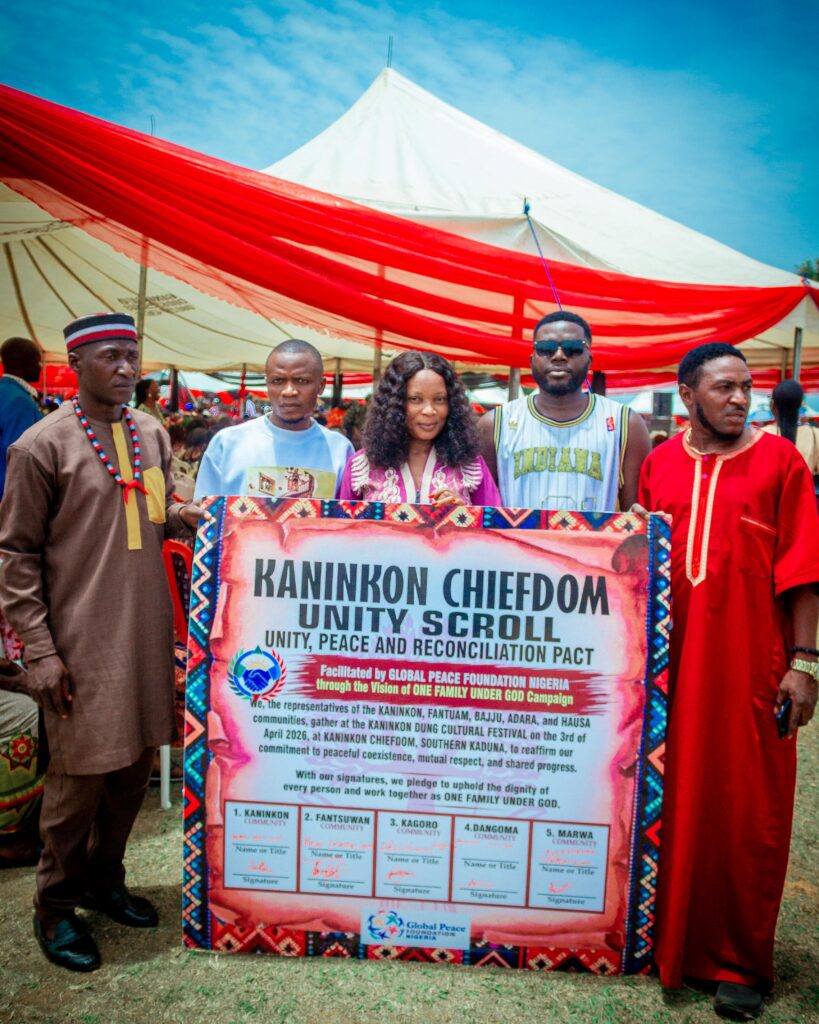 Five people stand outdoors at the Dung Nikyob Cultural Festival, posing with a large sign titled