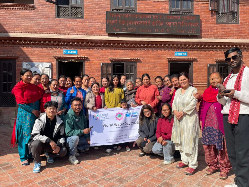 A group of people stand together outside a brick building holding a banner that reads “World Water Day 2023,” showing their commitment to environmental stewardship.